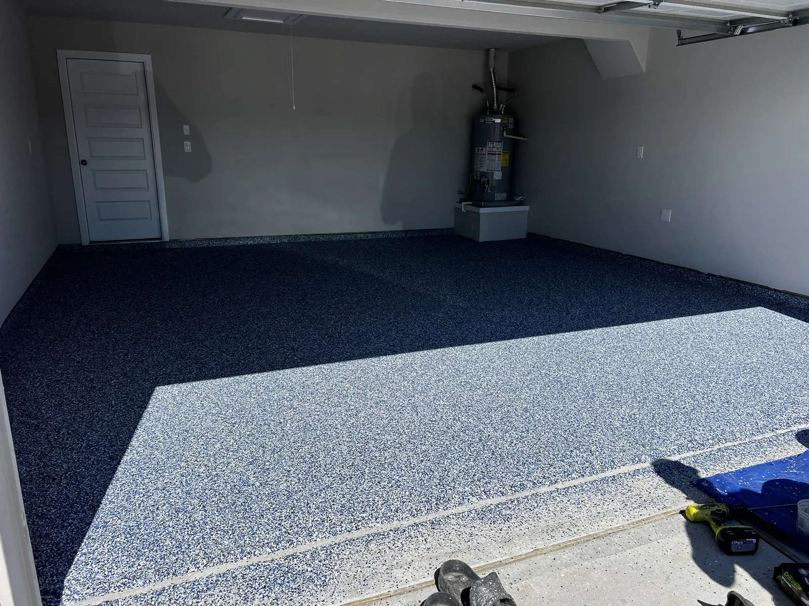 Garage floor in navy blue flake with sunlight across the front half